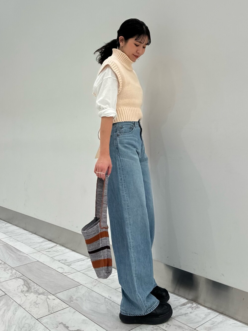 ホワイト系のワンピース、ホワイト系のTシャツ/カットソー、グレー系のハンドバッグを着用したレディースの冬コーディネートの2枚目の写真