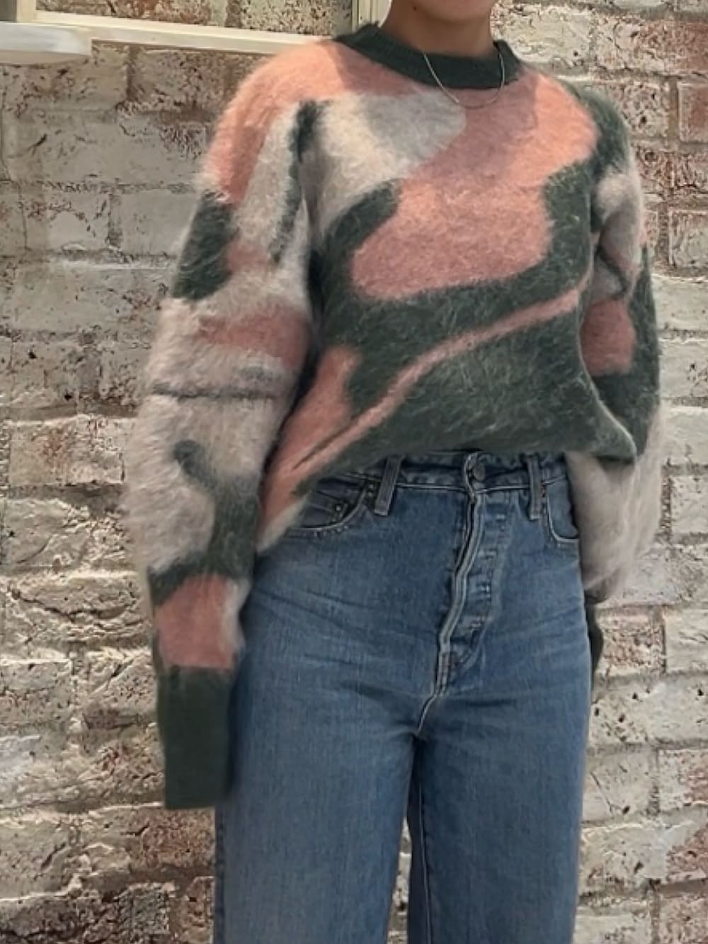 ブラック系のブーツ、グリーン系のニット/セーター、ブルー系のデニムパンツを着用したレディースの秋コーディネートの3枚目の写真