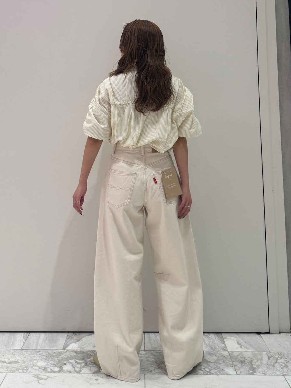 ホワイト系のデニムパンツ、イエロー系のシャツ/ブラウス、イエロー系のサンダルを着用したレディースの春コーディネートの4枚目の写真