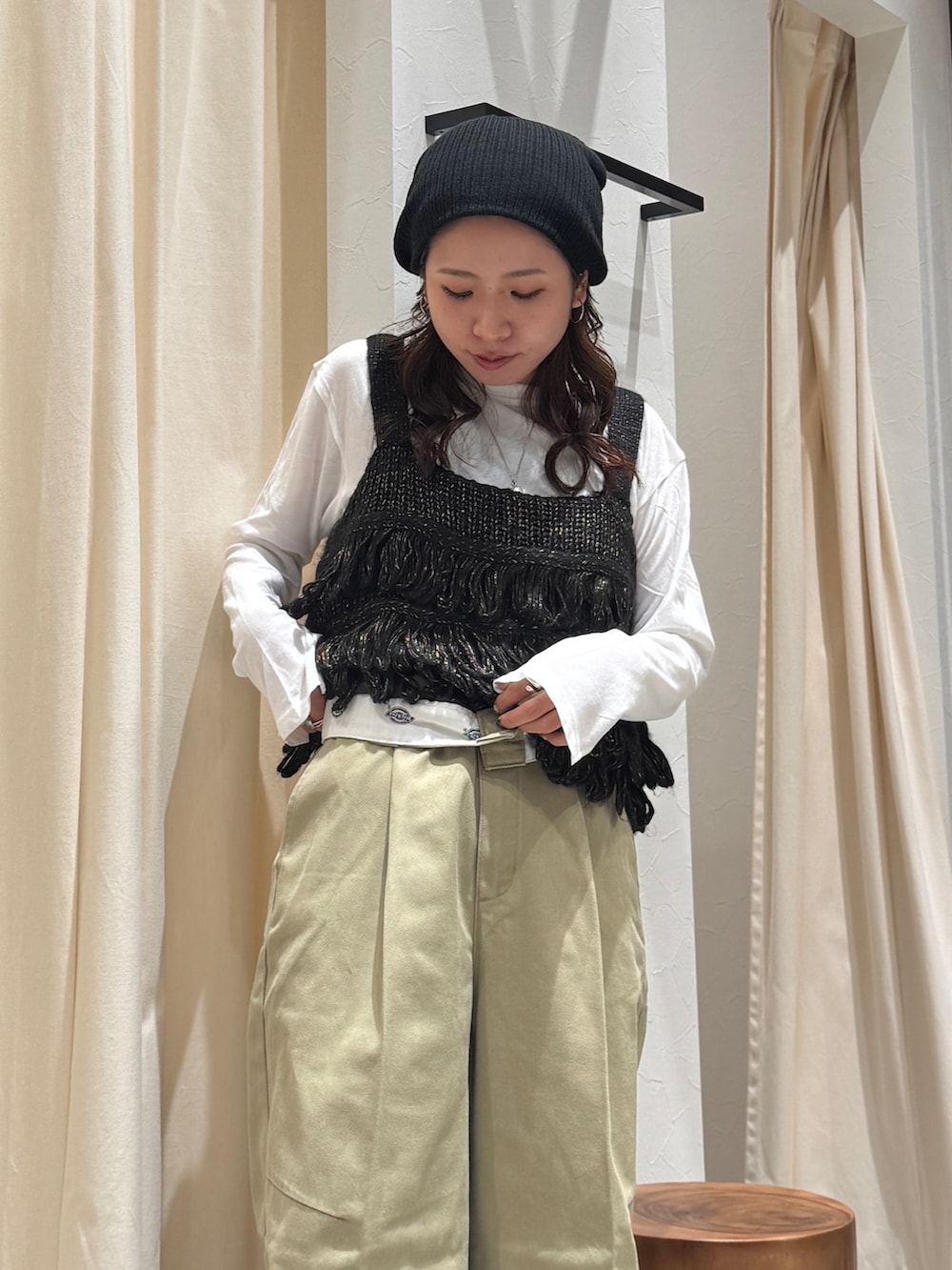 ベージュ系のその他パンツ、ブラック系のニット/セーター、ホワイト系のTシャツ/カットソーを着用したレディースの秋コーディネートの6枚目の写真