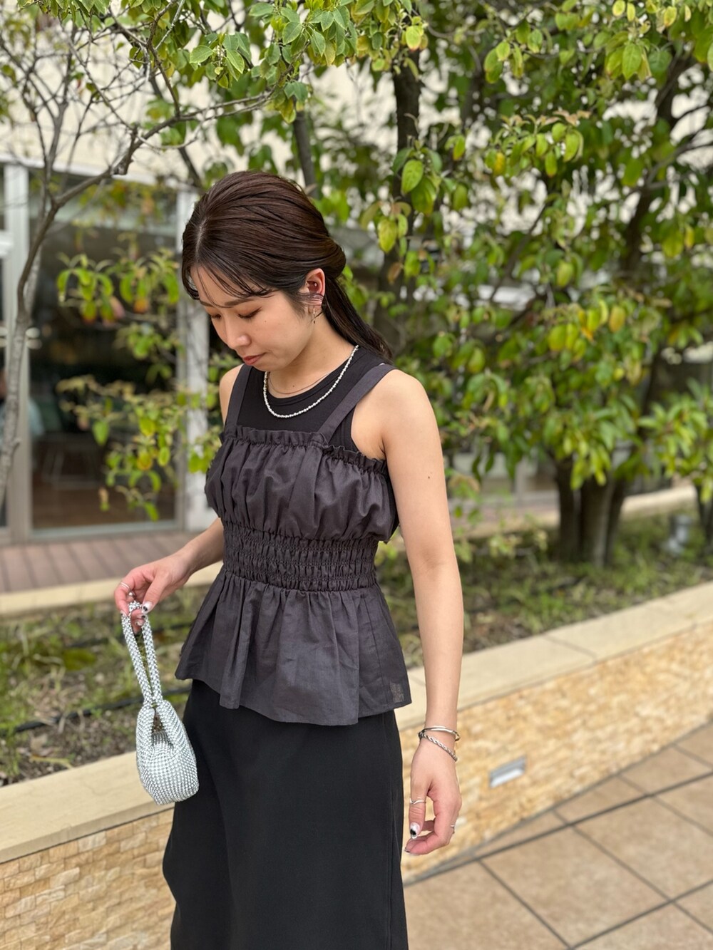 ブラック系のワンピース、グレー系のキャミソール、シルバー系のハンドバッグを着用したレディースの春コーディネートの8枚目の写真