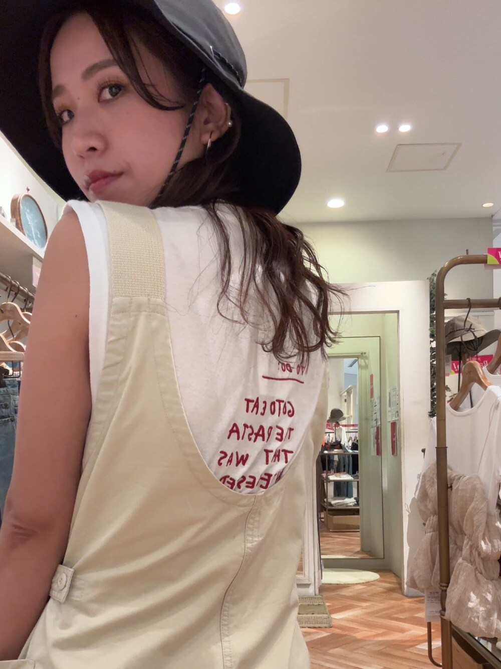 ベージュ系のサロペット/オーバーオール、ホワイト系のTシャツ/カットソー、ブラック系のサンダルを着用したレディースの夏コーディネートの6枚目の写真