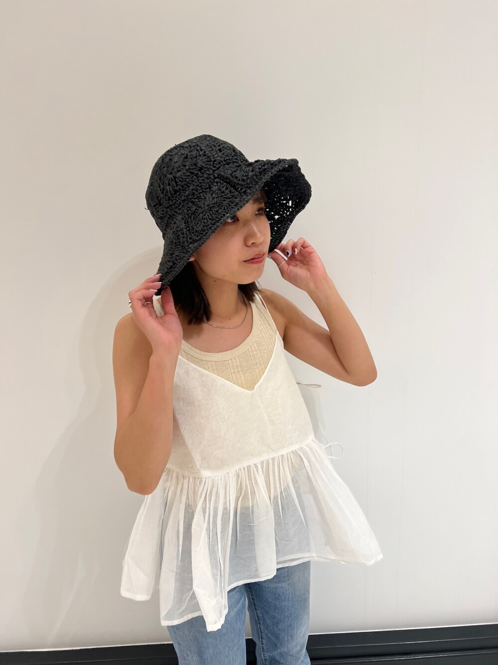 ホワイト系のシャツ/ブラウス、ベージュ系のタンクトップ、ブルー系のデニムパンツを着用したレディースの春コーディネートの8枚目の写真