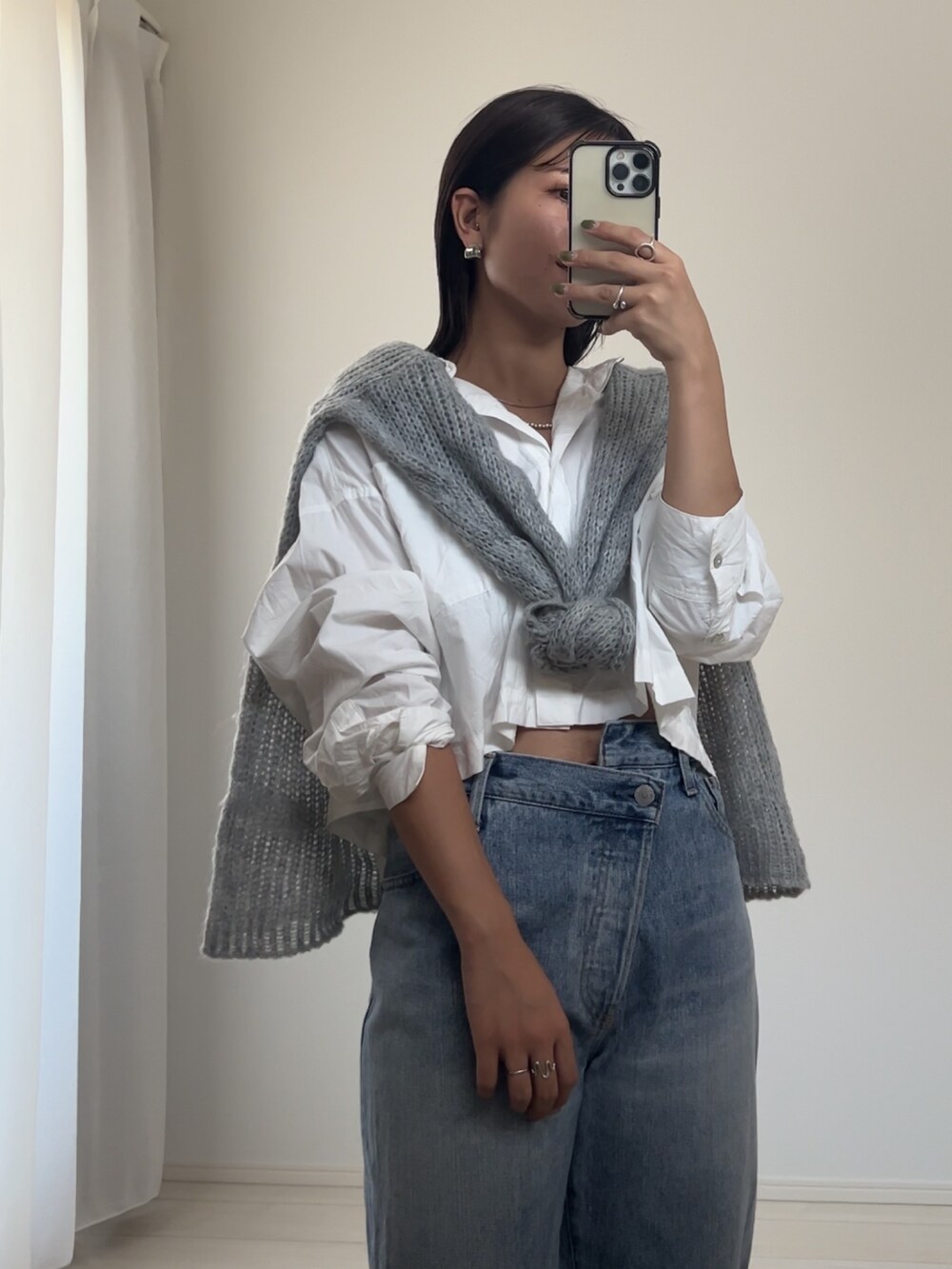 ブルー系のデニムパンツ、ホワイト系のシャツ/ブラウス、グレー系のニット/セーターを着用したレディースの秋コーディネートの3枚目の写真