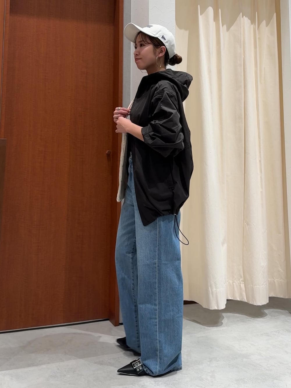 ブラック系のブルゾン、ブラック系のTシャツ/カットソー、ブルー系のデニムパンツを着用したレディースの春コーディネートの5枚目の写真