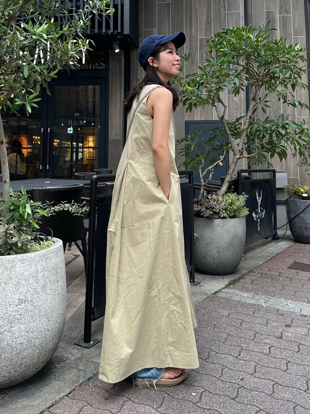 ベージュ系のワンピース、ブルー系のデニムパンツを着用したレディースの春コーディネートの7枚目の写真