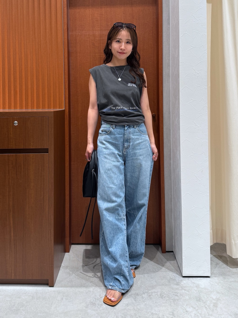 グレー系のタンクトップ、ブルー系のデニムパンツ、その他のサンダルを着用したレディースの夏コーディネートの2枚目の写真