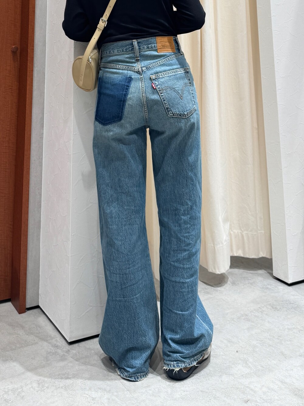 ブルー系のデニムパンツ、ブラック系のTシャツ/カットソー、グリーン系のニットキャップ/ビーニーを着用したレディースの夏コーディネートの7枚目の写真