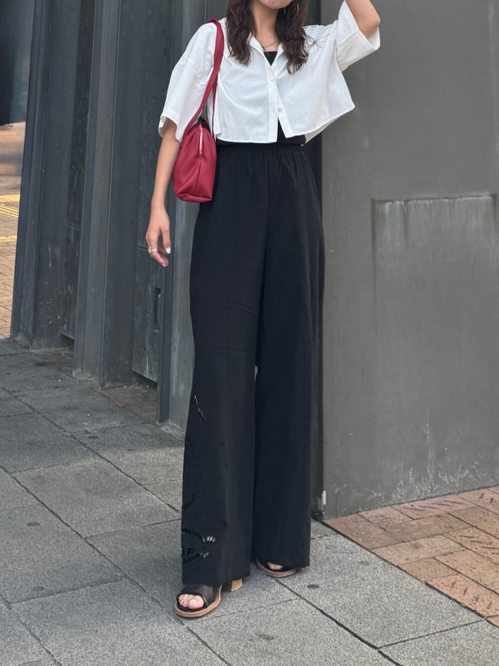 ブラック系のその他パンツ、ホワイト系のシャツ/ブラウス、レッド系のハンドバッグを着用したレディースの春コーディネートの7枚目の写真