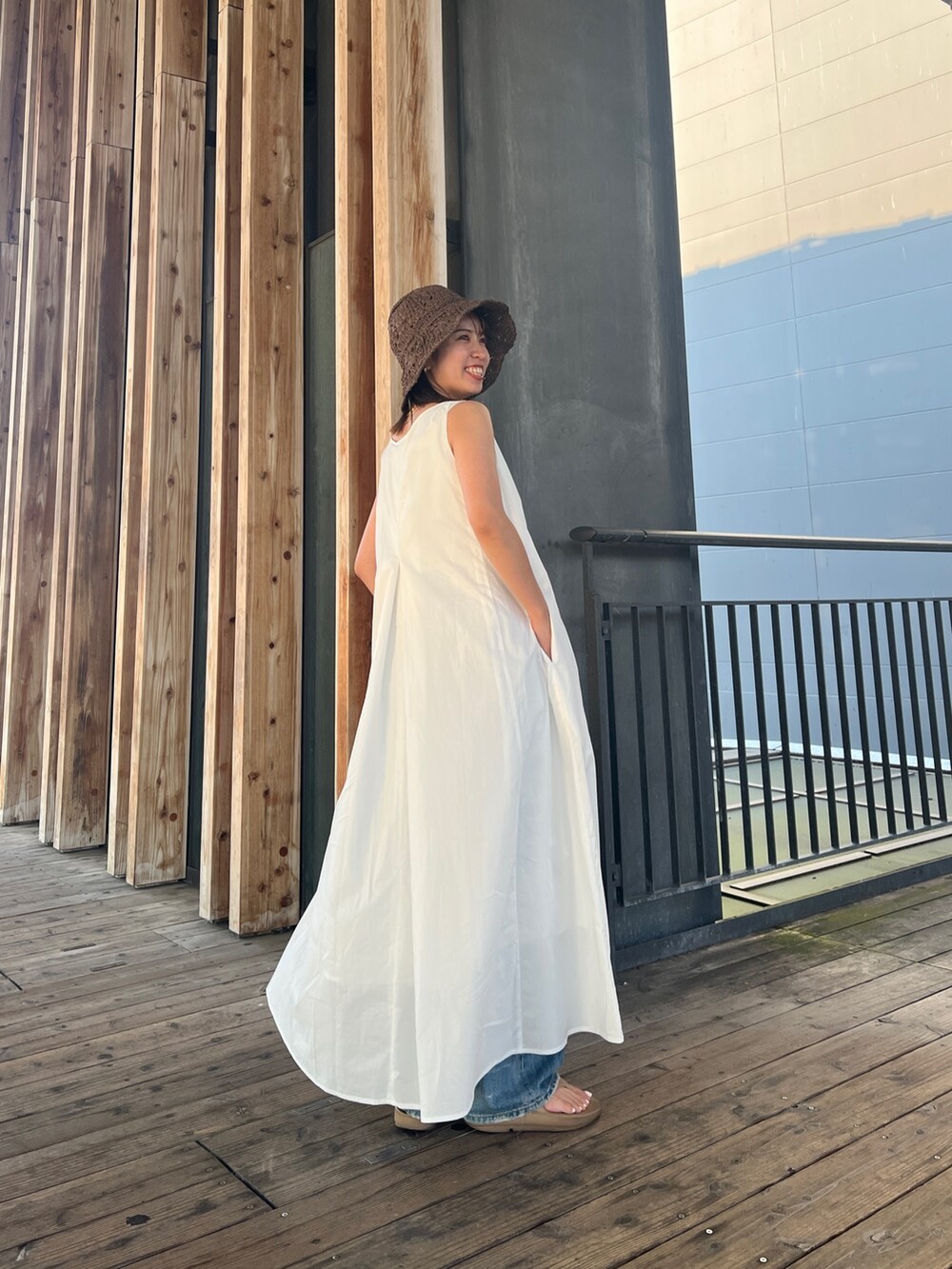 ホワイト系のワンピース、ブルー系のデニムパンツ、ブラウン系のハットを着用したレディースの夏コーディネートの4枚目の写真