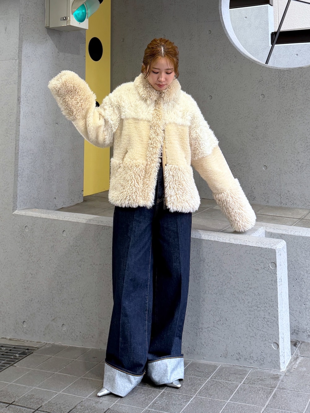 ホワイト系のブルゾン、シルバー系のパンプス、ブルー系のデニムパンツを着用したレディースの秋コーディネートの5枚目の写真