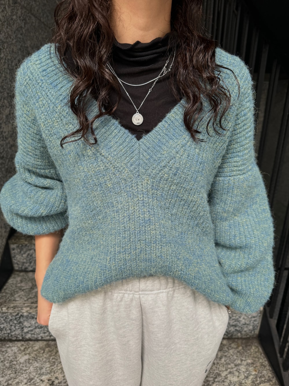 ブラック系のTシャツ/カットソー、グレー系のスウェットパンツ、ブルー系のニット/セーターを着用したレディースの秋コーディネートの5枚目の写真