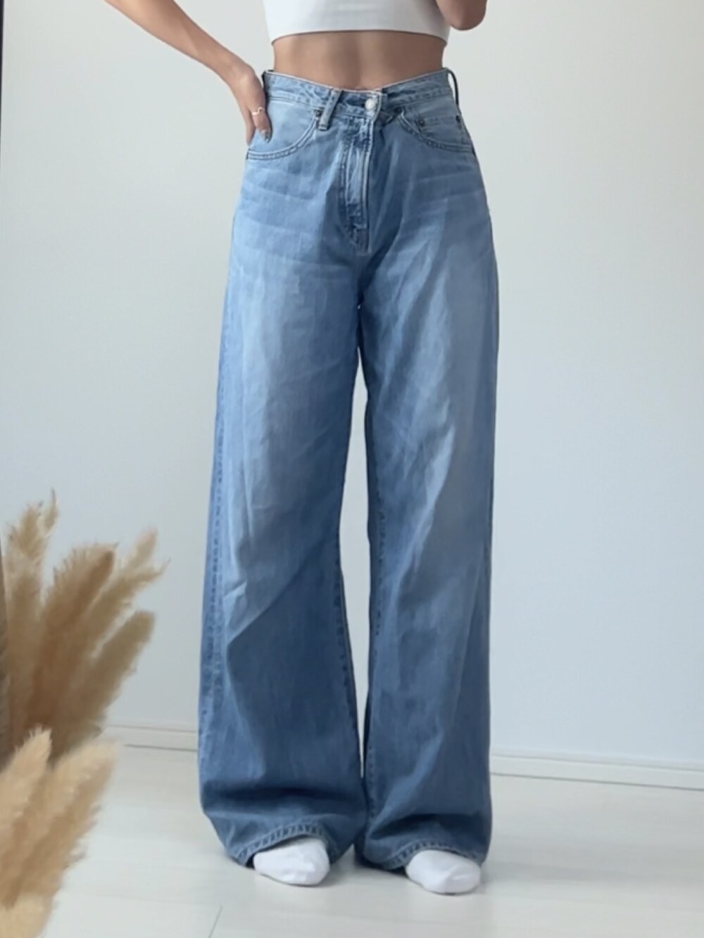 ブルー系のデニムパンツ、ブラック系のベルト、ブラック系のニットキャップ/ビーニーを着用したレディースの秋コーディネートの4枚目の写真