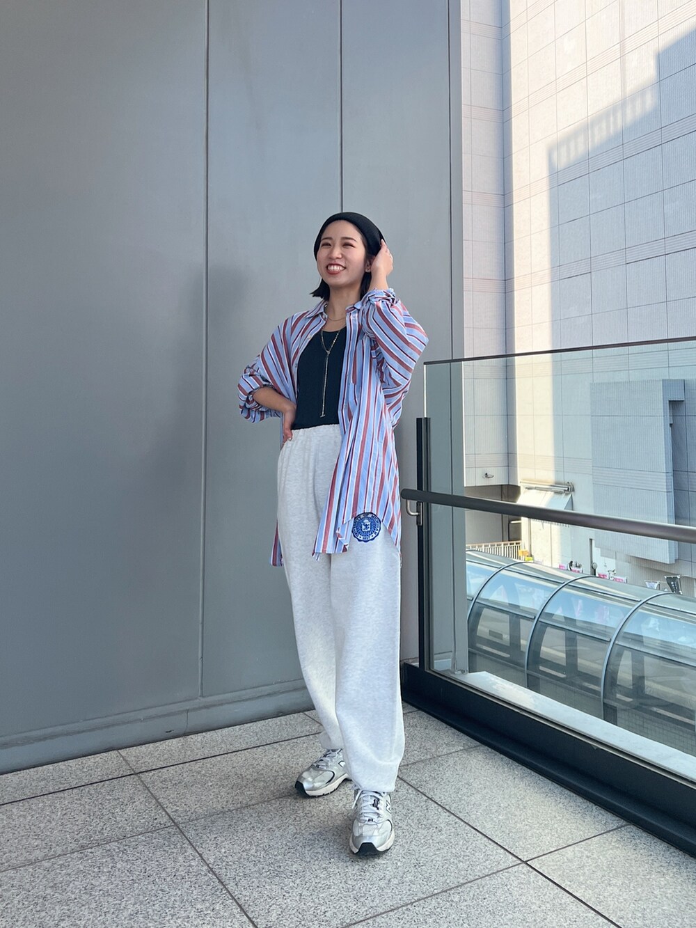 グレー系のスウェットパンツ、ブルー系のシャツ/ブラウス、グレー系のタンクトップを着用したレディースの冬コーディネートの2枚目の写真