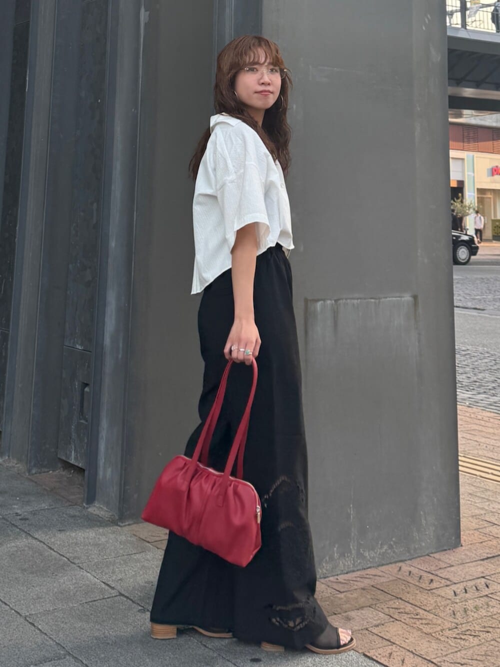 ブラック系のその他パンツ、ホワイト系のシャツ/ブラウス、レッド系のハンドバッグを着用したレディースの春コーディネートの4枚目の写真