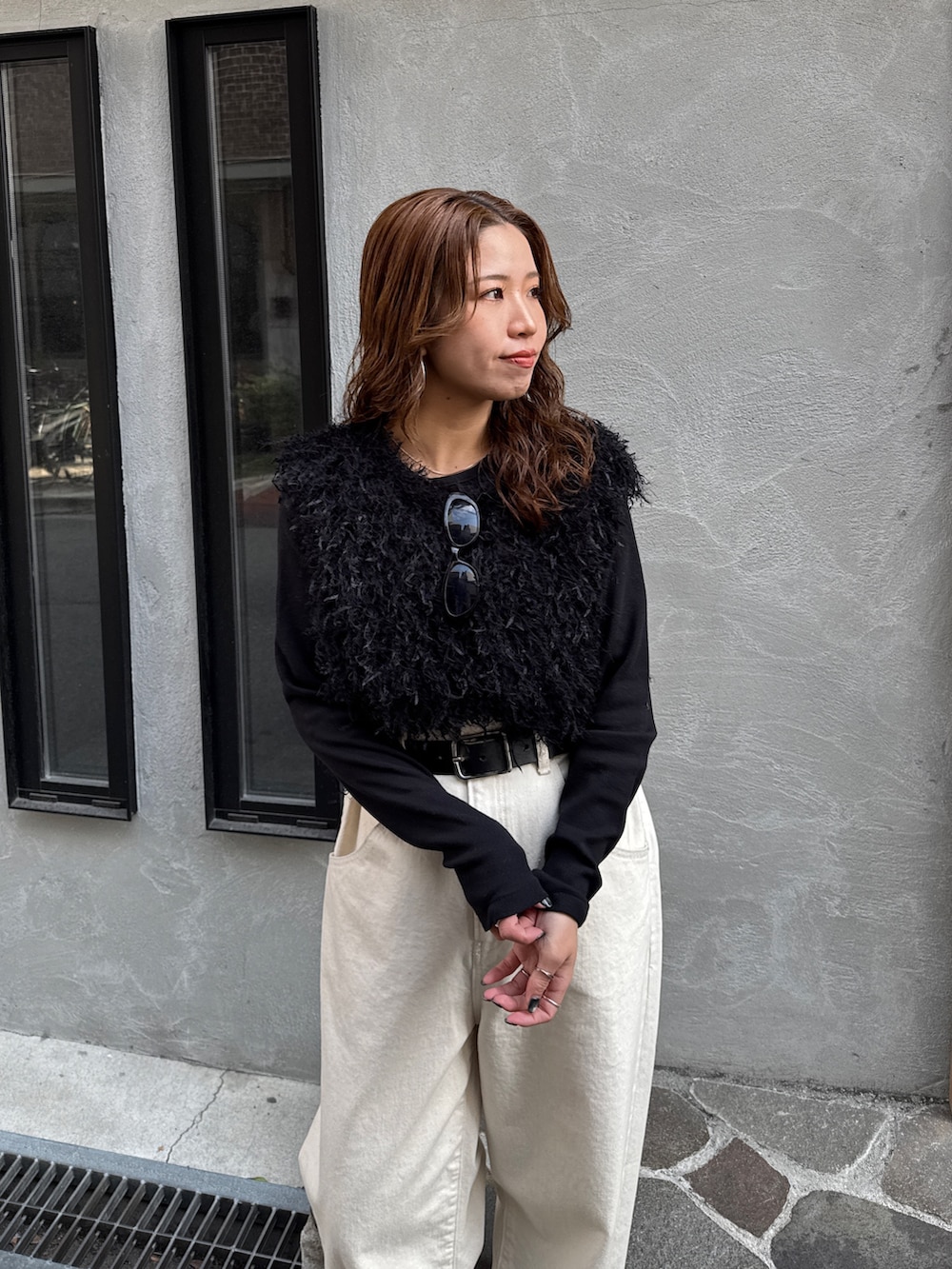 ホワイト系のデニムパンツ、ブラック系のニット/セーター、ブラック系のTシャツ/カットソーを着用したレディースの冬コーディネートの8枚目の写真