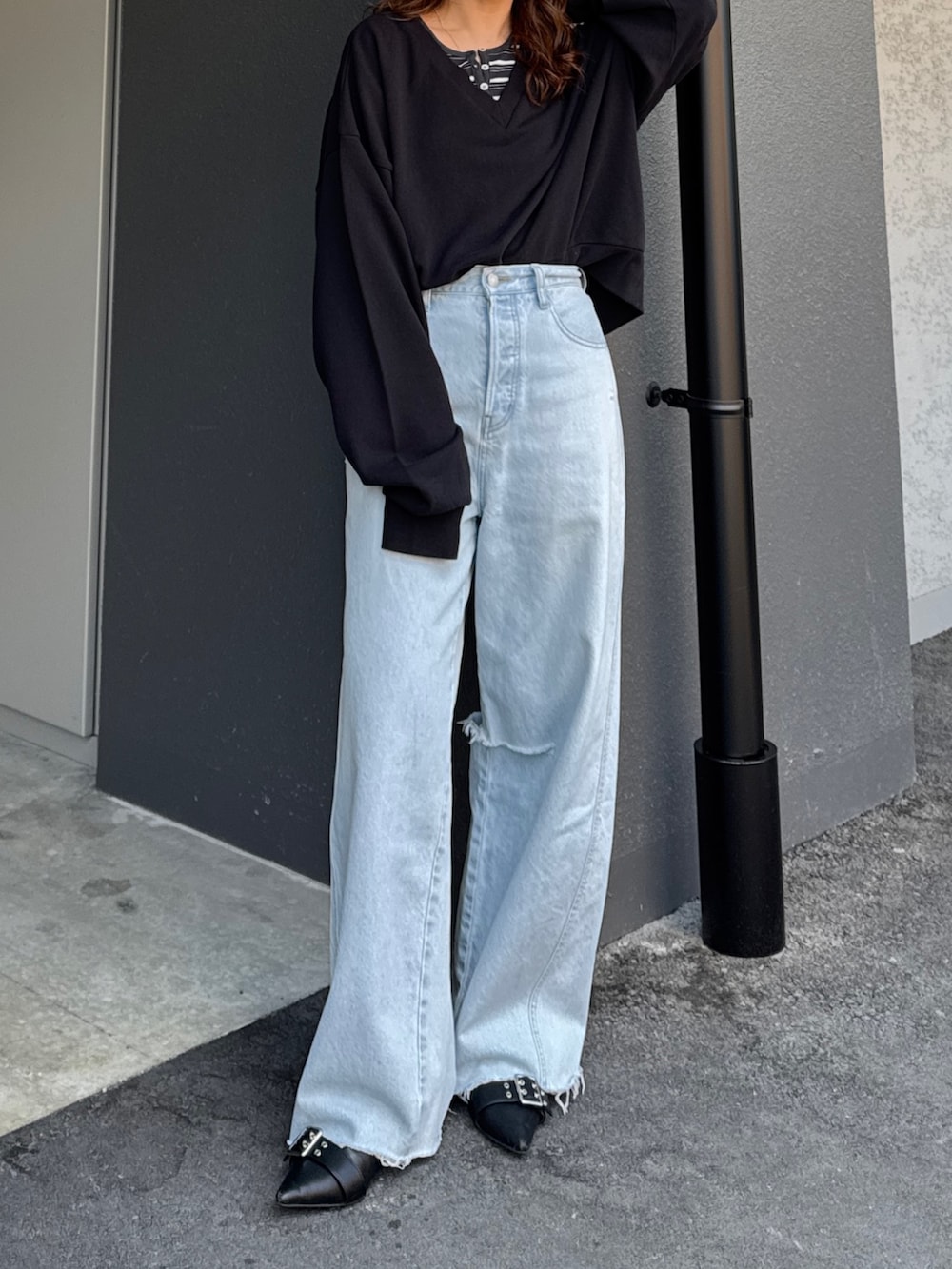 ブラック系のスウェット、グレー系のTシャツ/カットソー、ブルー系のデニムパンツを着用したレディースの春コーディネートの2枚目の写真