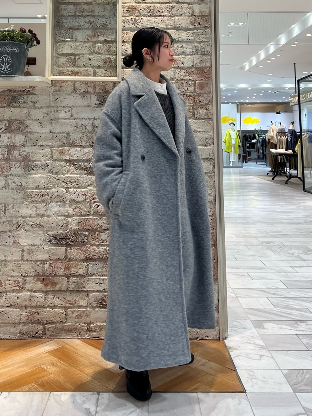 グレー系のニット/セーター、ブルー系のデニムパンツ、ブラック系のローファーを着用したレディースの秋コーディネートの6枚目の写真