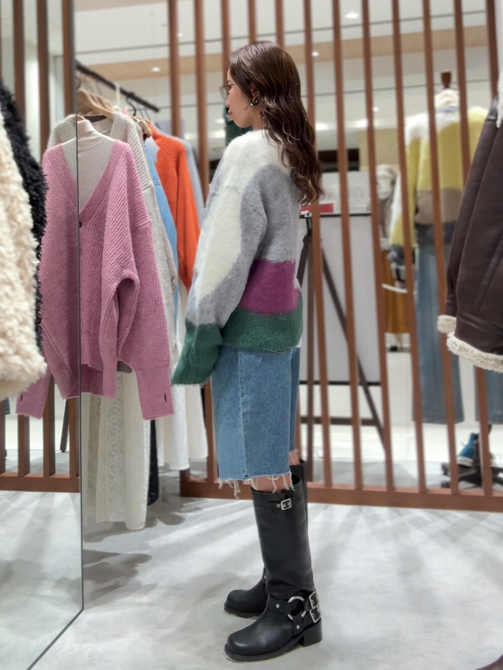 グリーン系のニット/セーター、ホワイト系のTシャツ/カットソー、ブルー系のデニムパンツを着用したレディースの秋コーディネートの5枚目の写真