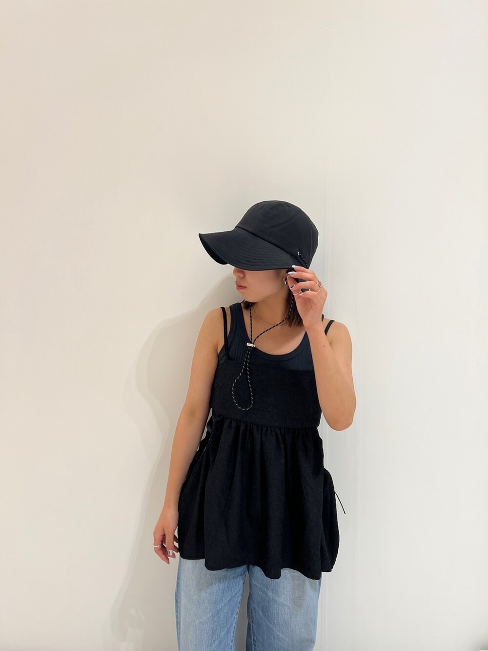 グレー系のタンクトップ、ブルー系のデニムパンツ、ブラック系のシャツ/ブラウスを着用したレディースの春コーディネートの9枚目の写真