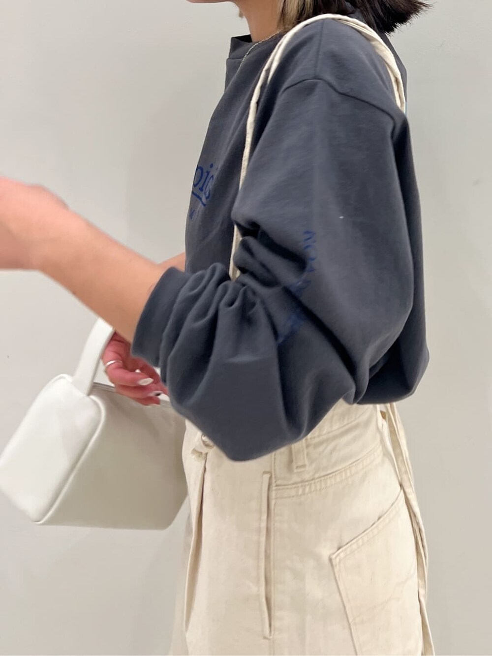 ホワイト系のデニムパンツ、グレー系のTシャツ/カットソーを着用したレディースの冬コーディネートの5枚目の写真