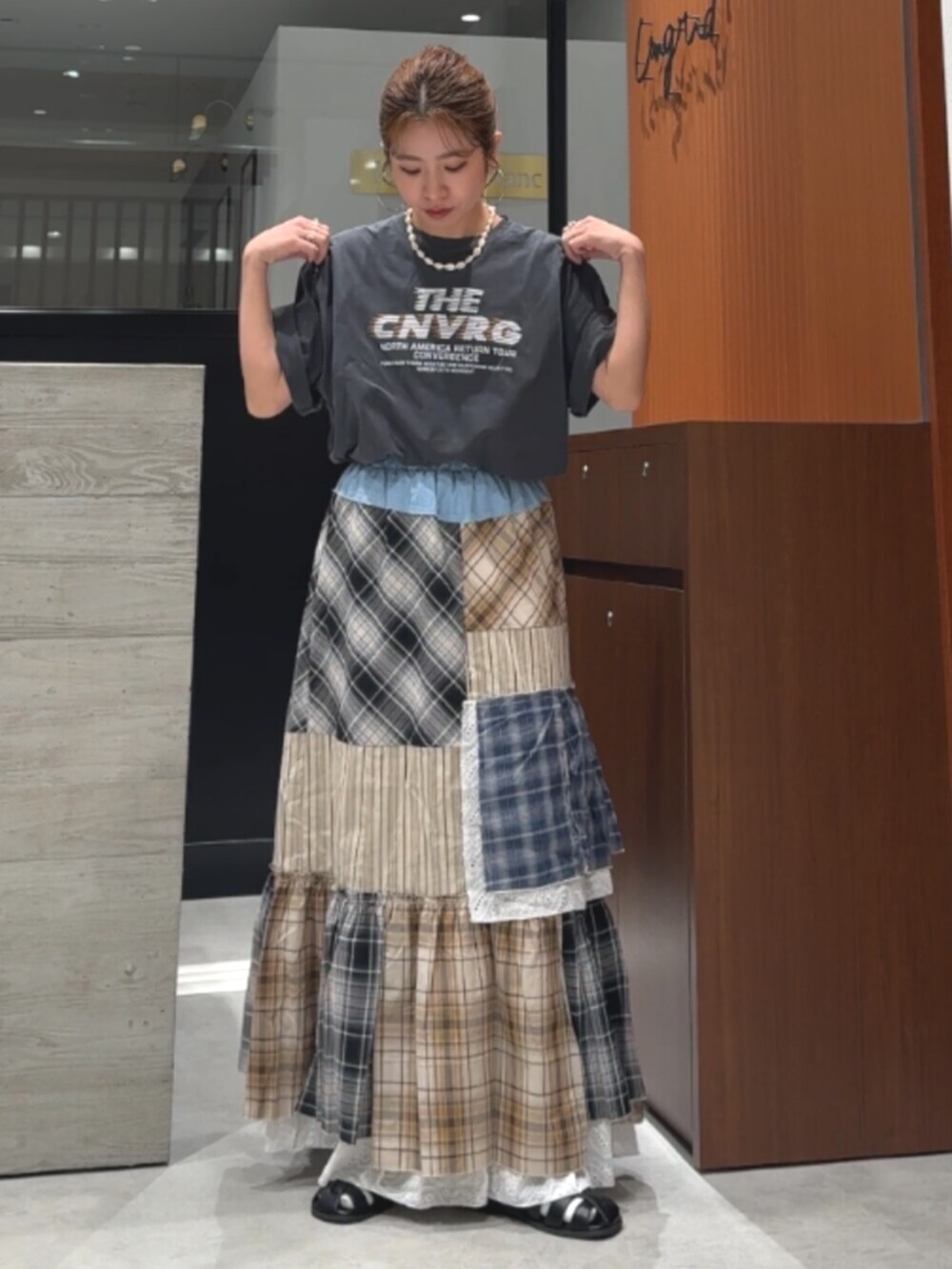 グレー系のTシャツ/カットソー、ブラック系のサンダル、その他のスカートを着用したレディースの春コーディネートの10枚目の写真