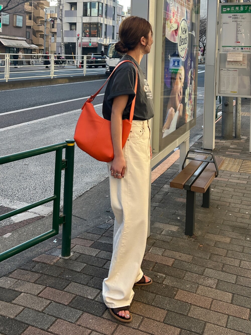 グレー系のTシャツ/カットソー、ホワイト系のデニムパンツ、オレンジ系のショルダーバッグを着用したレディースの春コーディネートの3枚目の写真