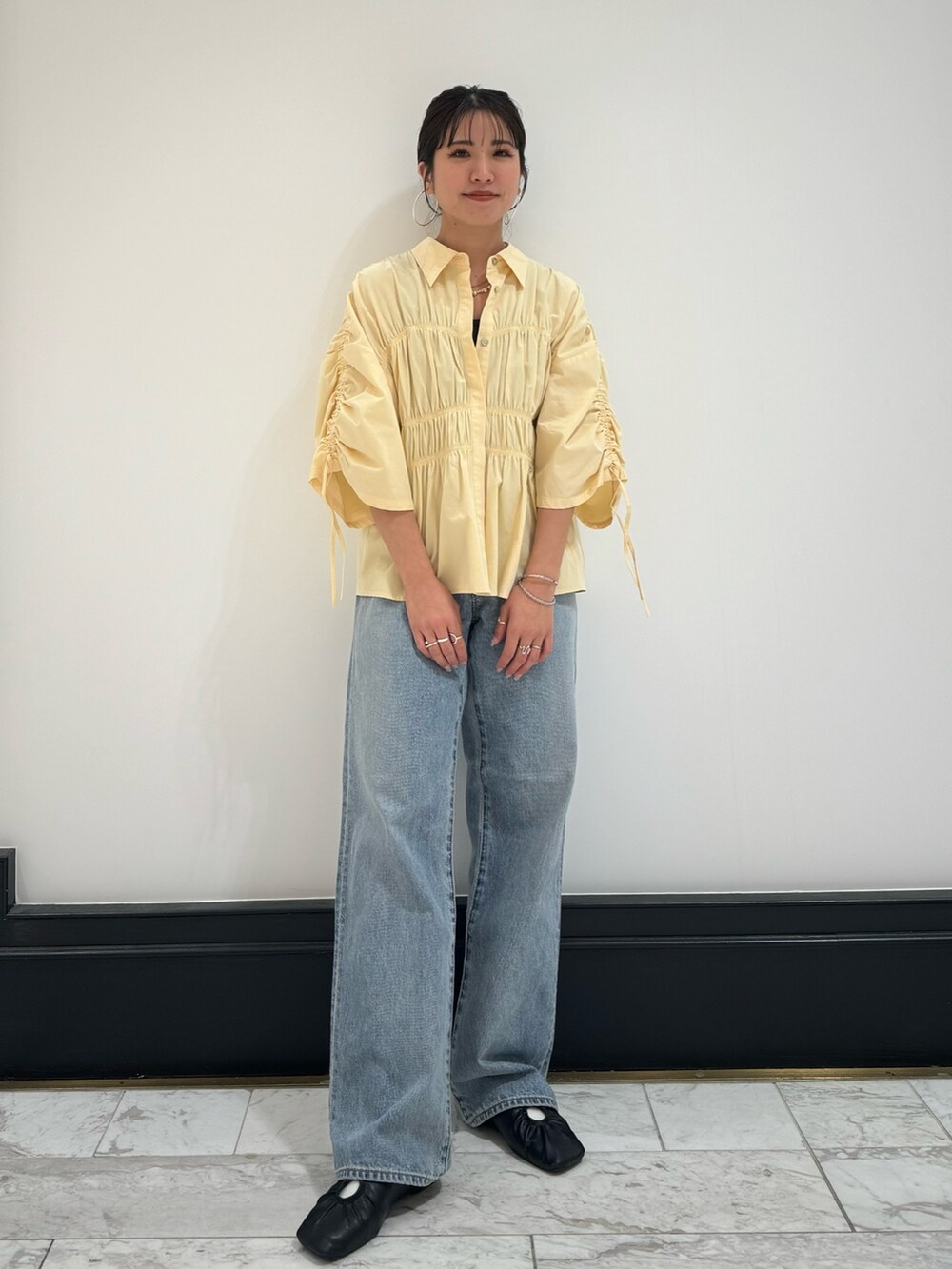 イエロー系のシャツ/ブラウス、ブルー系のデニムパンツ、グレー系のTシャツ/カットソーを着用したレディースの春コーディネートの2枚目の写真