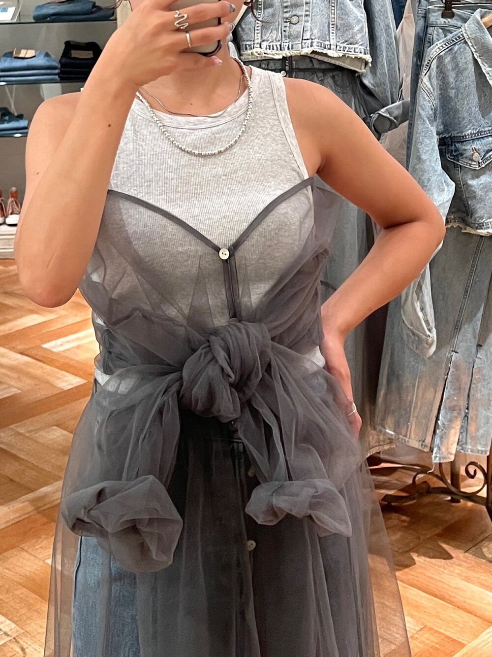 ブルー系のデニムパンツ、グレー系のワンピース、シルバー系のネックレスを着用したレディースの夏コーディネートの2枚目の写真