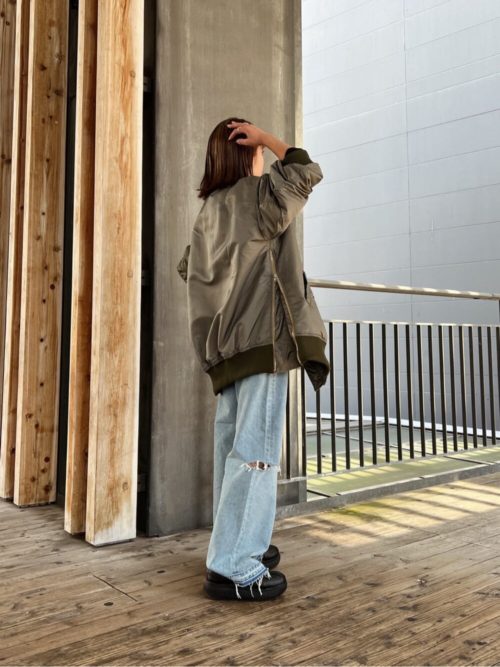 グリーン系のMA-1、ブルー系のデニムパンツ、ブルー系のデニムパンツを着用したレディースの秋コーディネートの6枚目の写真