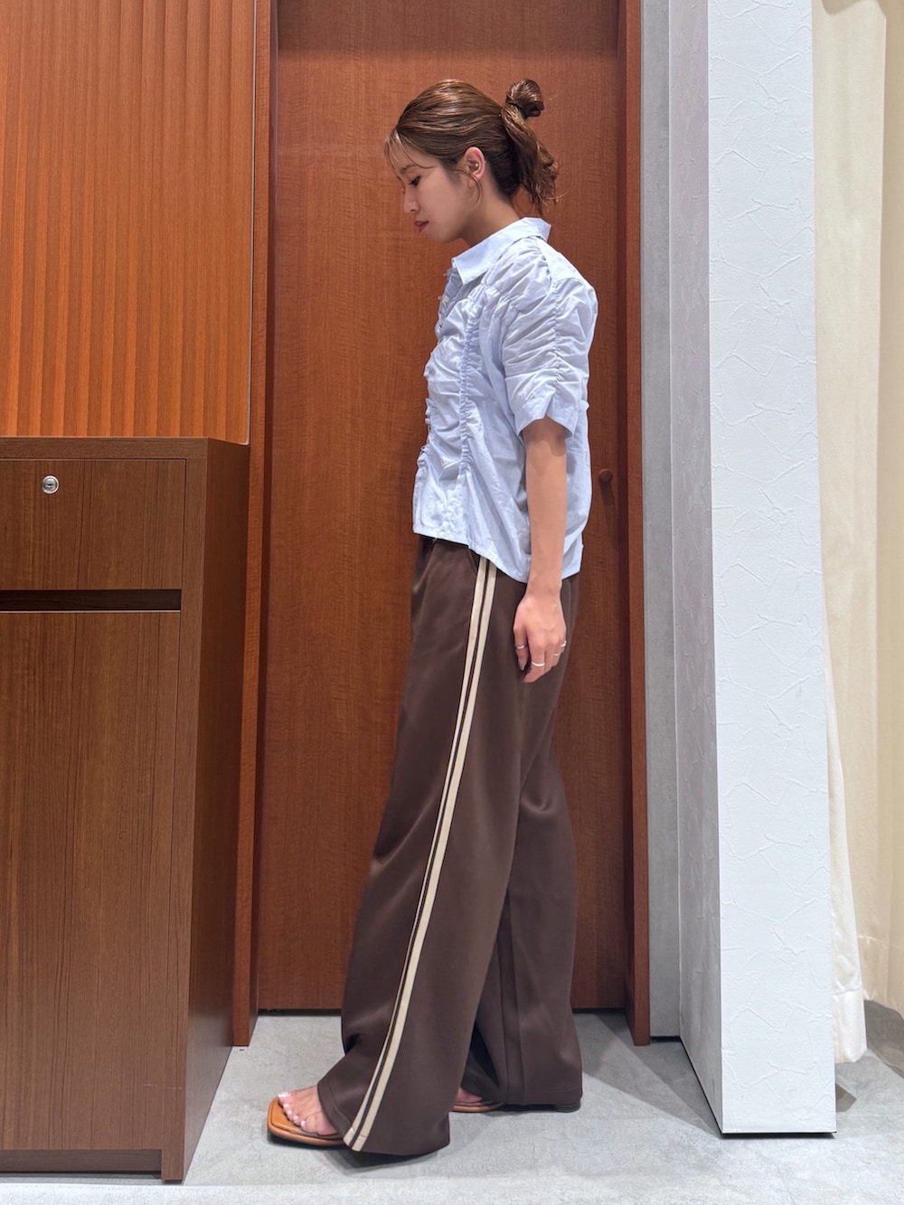 ブラウン系のその他パンツ、ブルー系のシャツ/ブラウス、ブラック系のハンドバッグを着用したレディースの夏コーディネートの4枚目の写真