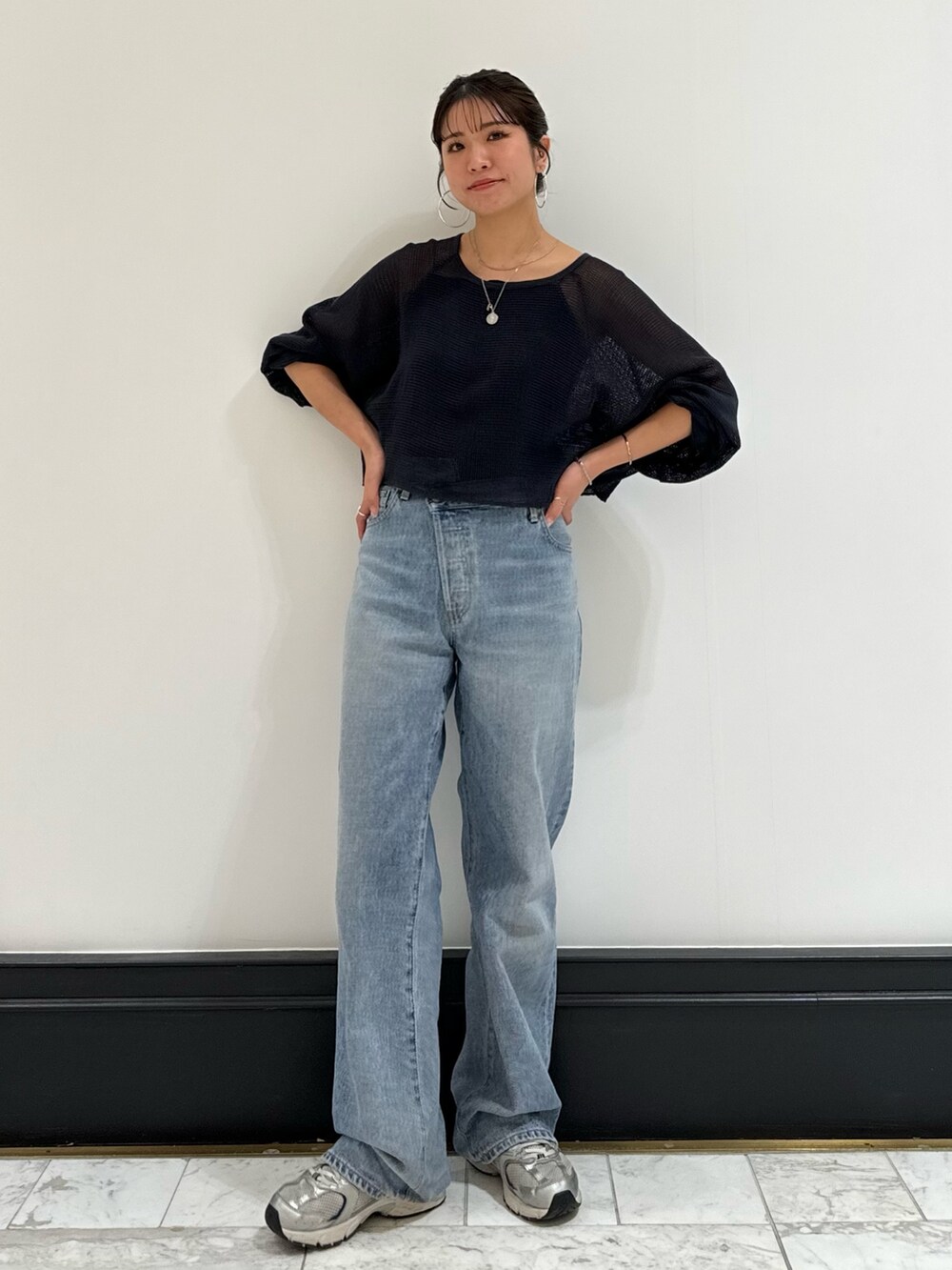 ブラック系のキャミソール、グレー系のTシャツ/カットソー、ブルー系のデニムパンツを着用したレディースの春コーディネートの6枚目の写真