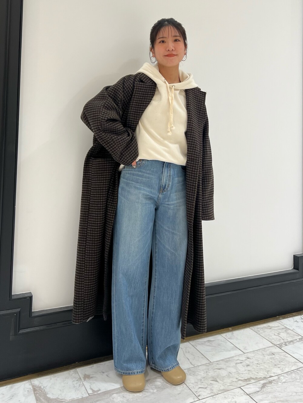 ベージュ系のブーツ、ブルー系のデニムパンツ、その他のチェスターコートを着用したレディースの冬コーディネートの10枚目の写真