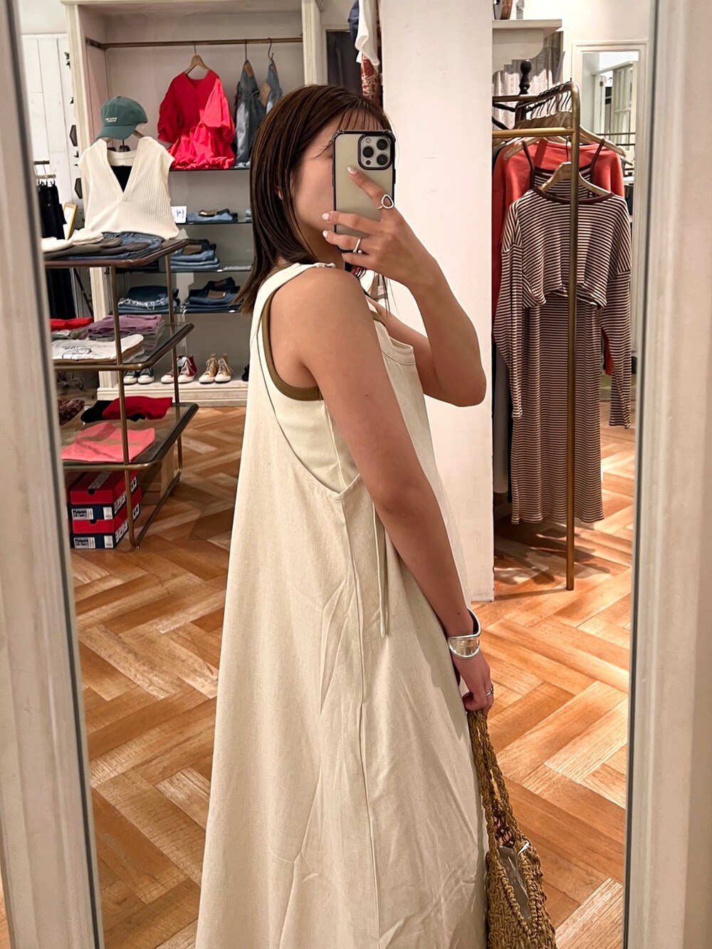 ホワイト系のワンピース、ホワイト系のTシャツ/カットソー、ブラウン系のハンドバッグを着用したレディースの夏コーディネートの2枚目の写真