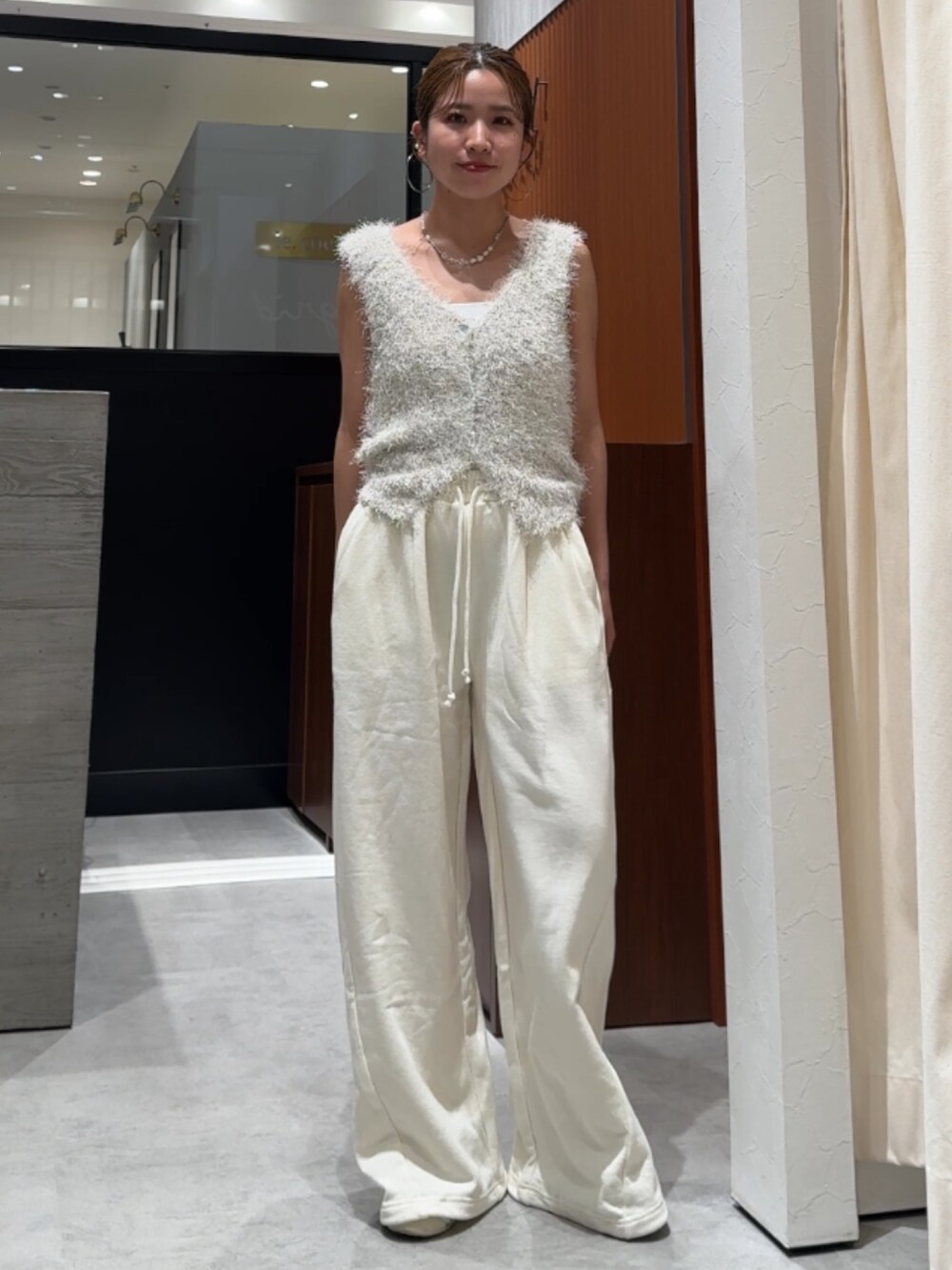ホワイト系のスウェットパンツ、ホワイト系のベストを着用したレディースの春コーディネートの7枚目の写真