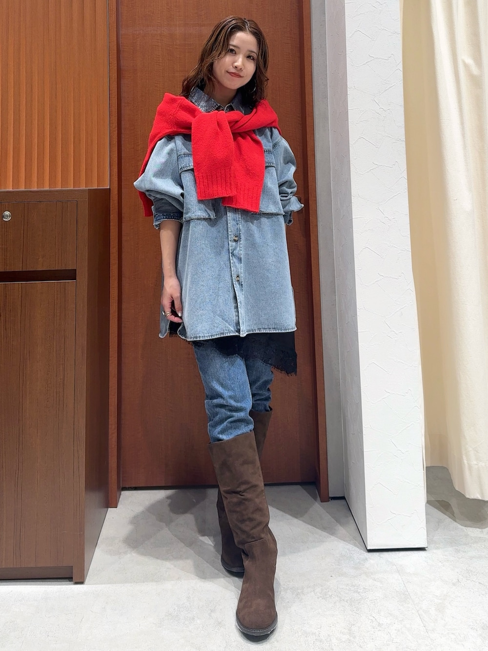 ブルー系のシャツ/ブラウス、レッド系のニット/セーター、ブラック系のキャミソールを着用したレディースの冬コーディネートの9枚目の写真