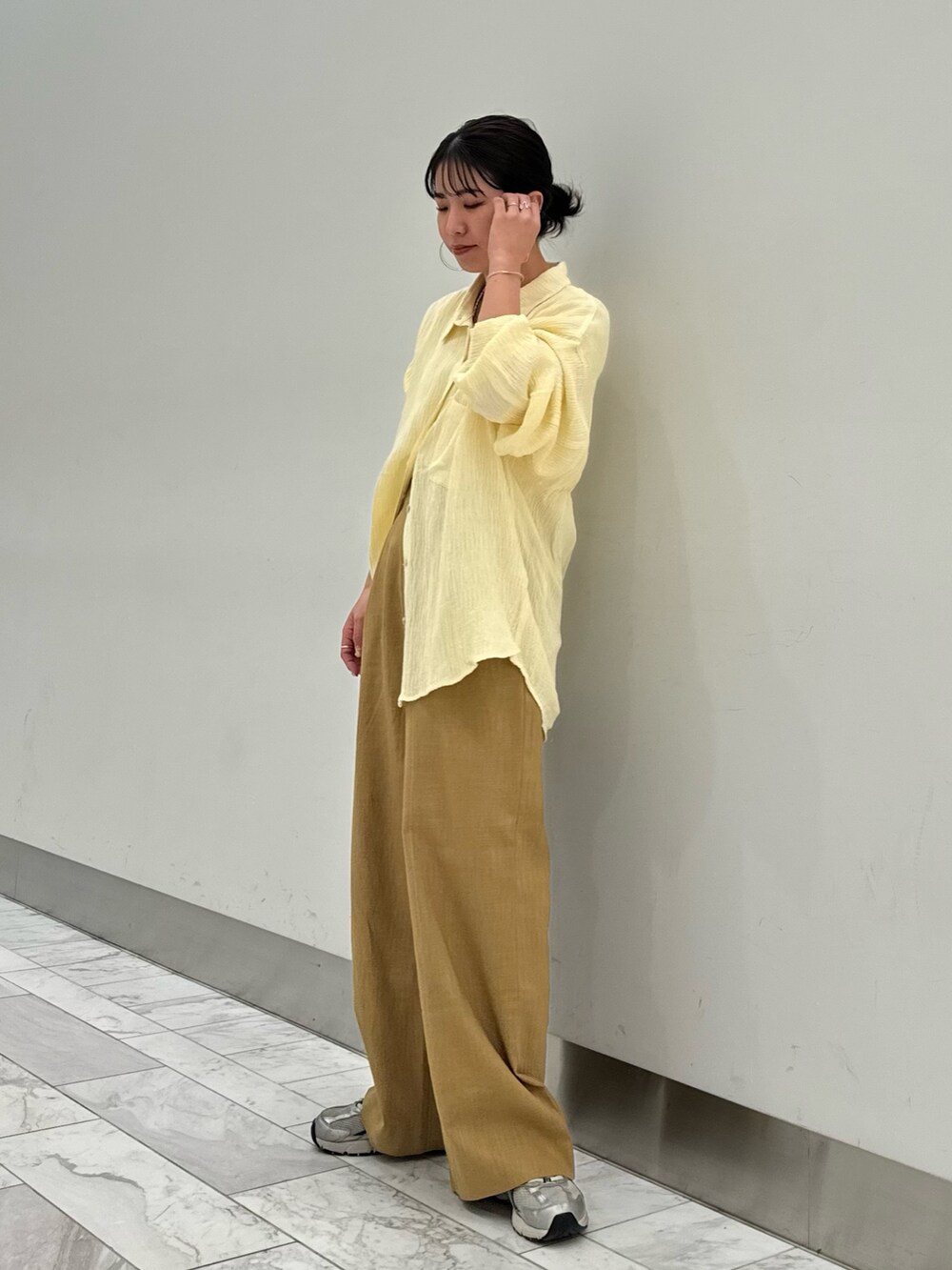 ベージュ系のその他パンツ、ホワイト系のキャミソール、イエロー系のシャツ/ブラウスを着用したレディースの春コーディネートの5枚目の写真