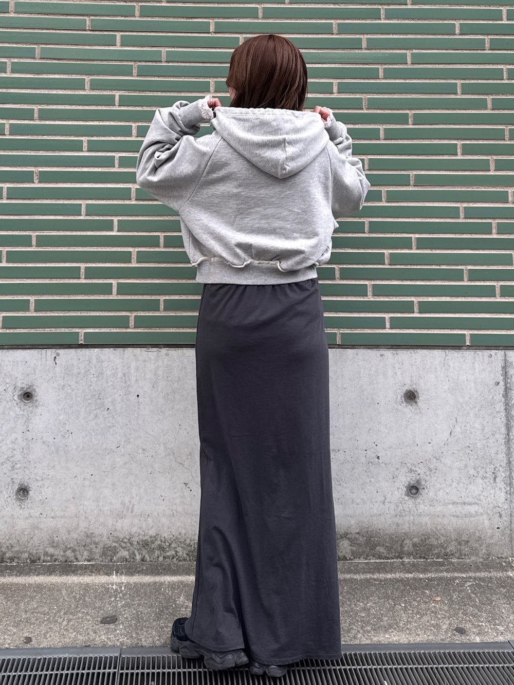 グレー系のパーカー、ホワイト系のTシャツ/カットソー、グレー系のスカートを着用したレディースの冬コーディネートの3枚目の写真