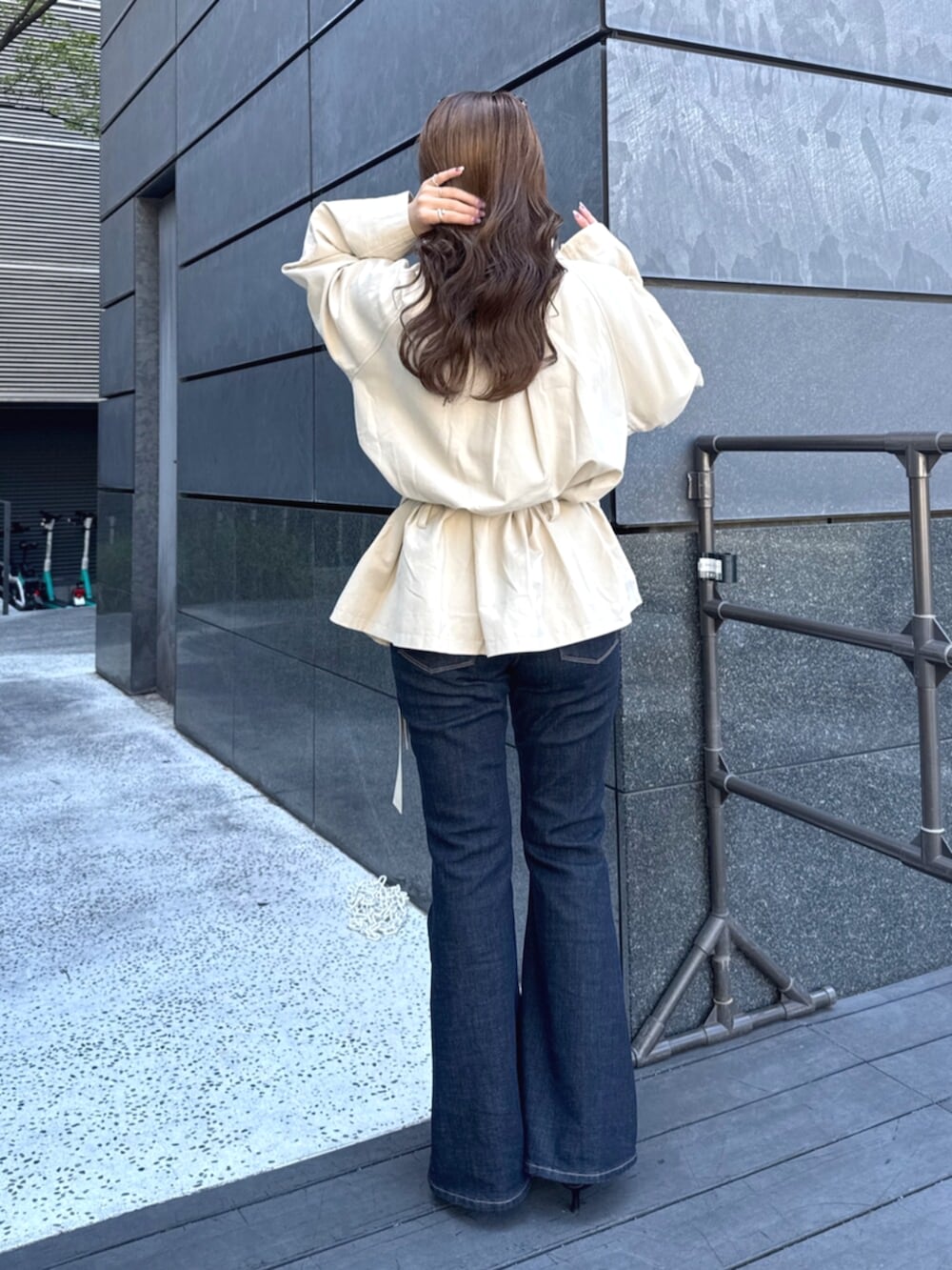 ベージュ系のトレンチコート、ブルー系のデニムパンツ、ブラック系のパンプスを着用したレディースの秋コーディネートの4枚目の写真