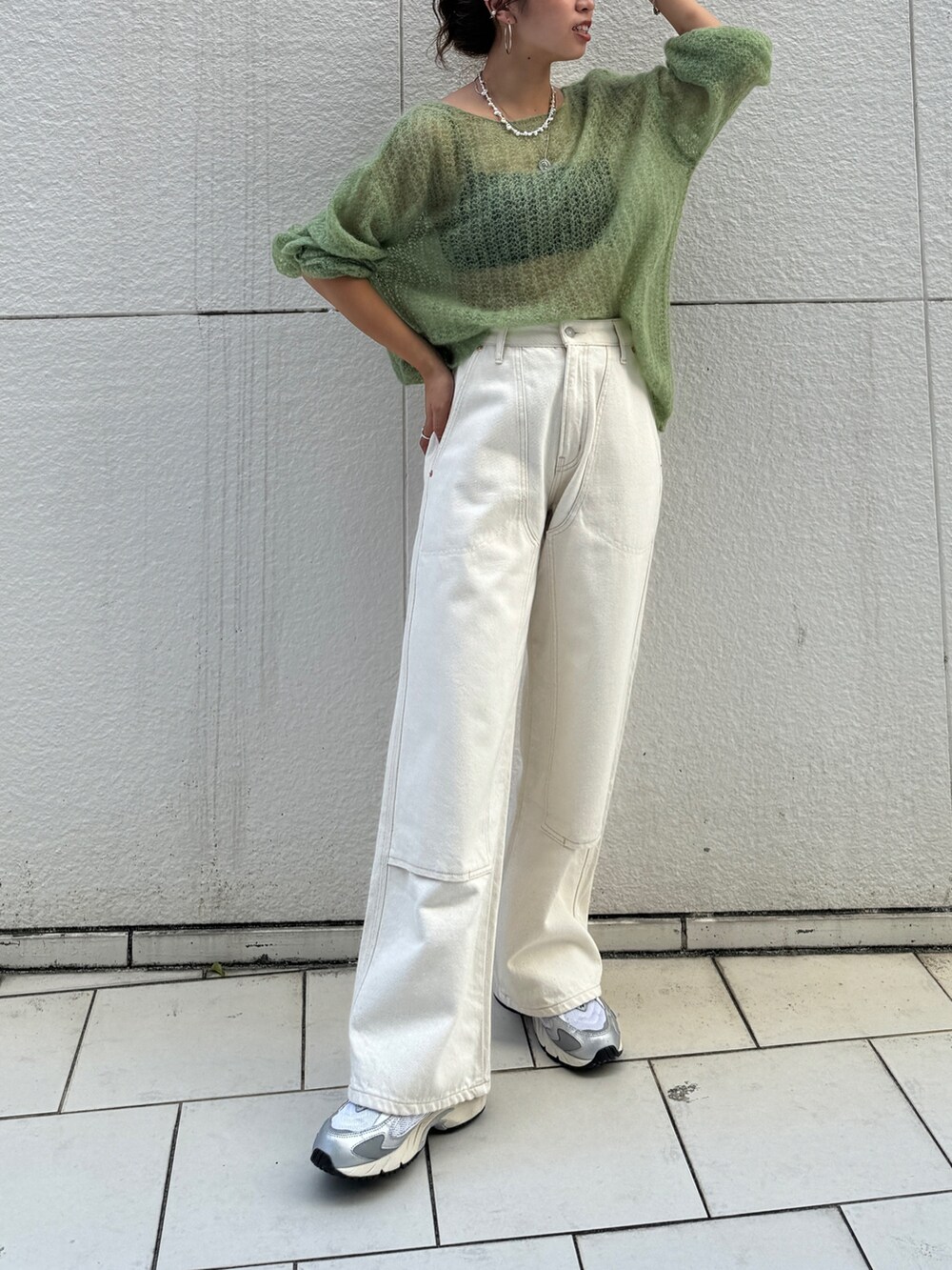 ホワイト系のデニムパンツ、グリーン系のニット/セーターを着用したレディースの秋コーディネートの2枚目の写真