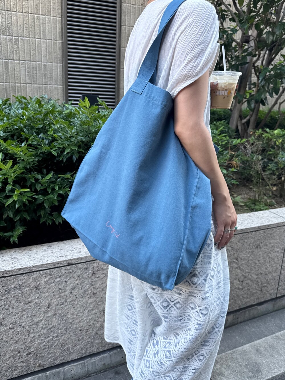 ホワイト系のワンピース、ブルー系のトートバッグを着用したレディースの夏コーディネートの10枚目の写真