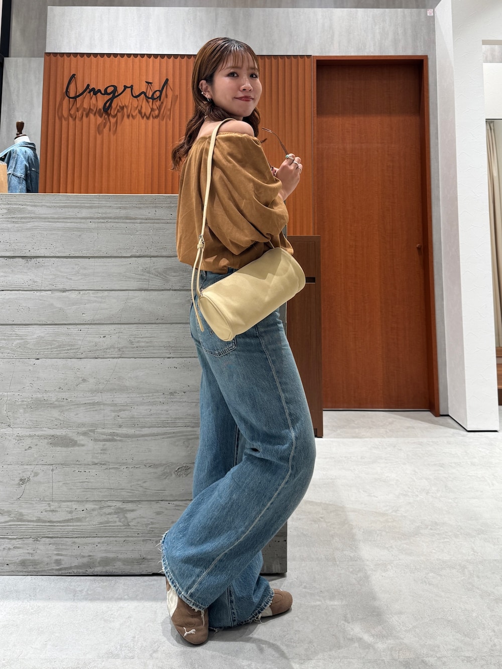 ブルー系のデニムパンツ、イエロー系のシャツ/ブラウス、ブラウン系のサングラスを着用したレディースの夏コーディネートの6枚目の写真