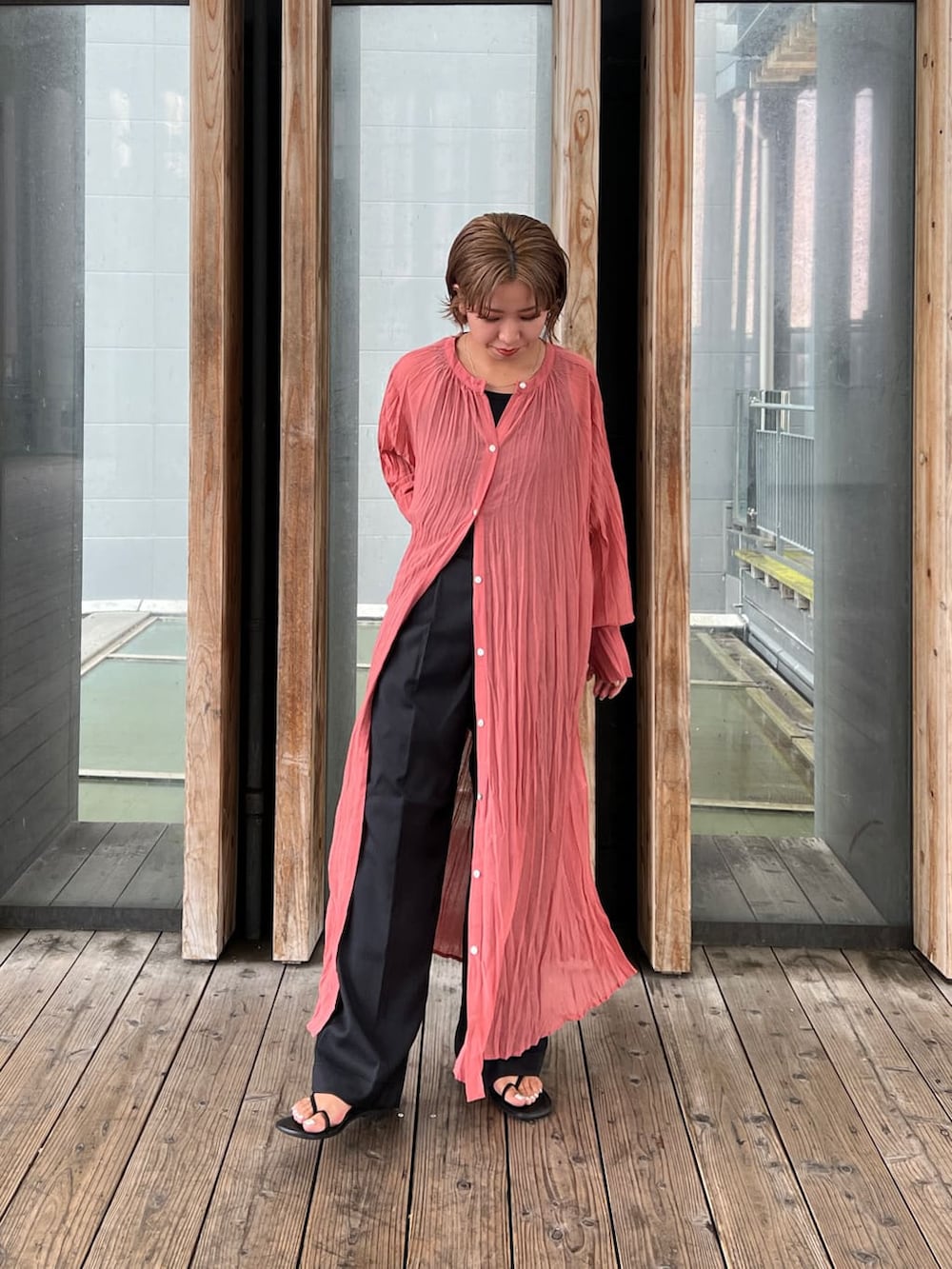 ブラック系のタンクトップ、ピンク系のワンピース、グレー系のスラックスを着用したレディースの夏コーディネートの5枚目の写真