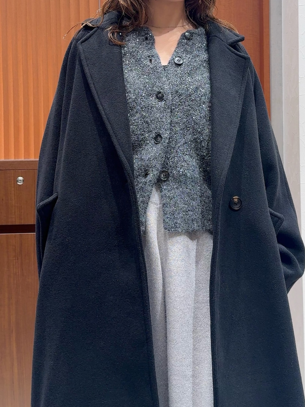 グレー系のカーディガン/ボレロ、グレー系のその他パンツ、ブラック系のチェスターコートを着用したレディースの冬コーディネートの6枚目の写真