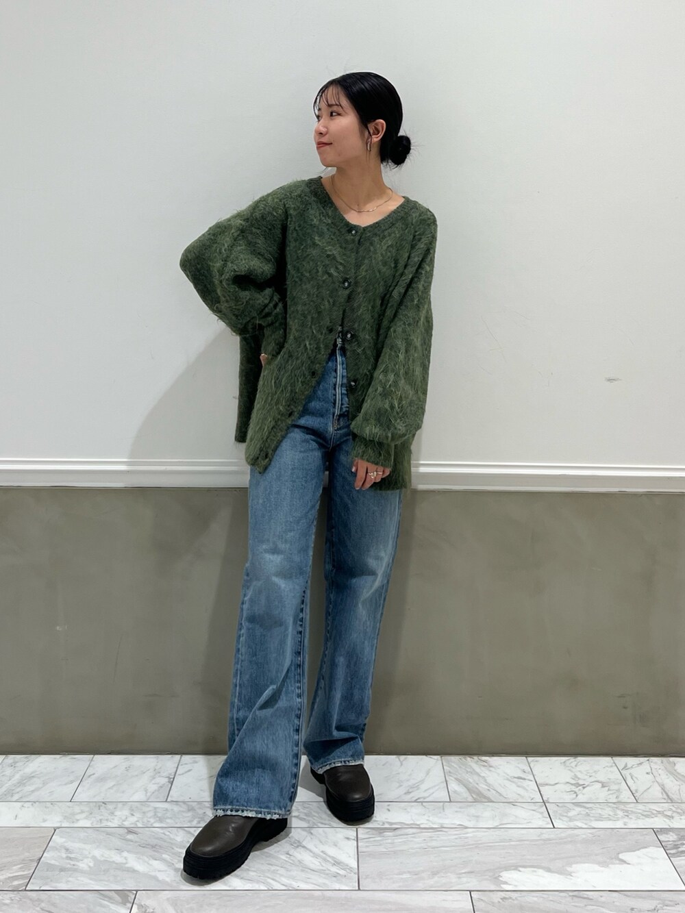 ブルー系のデニムパンツ、グリーン系のカーディガン/ボレロを着用したレディースの秋コーディネートの6枚目の写真