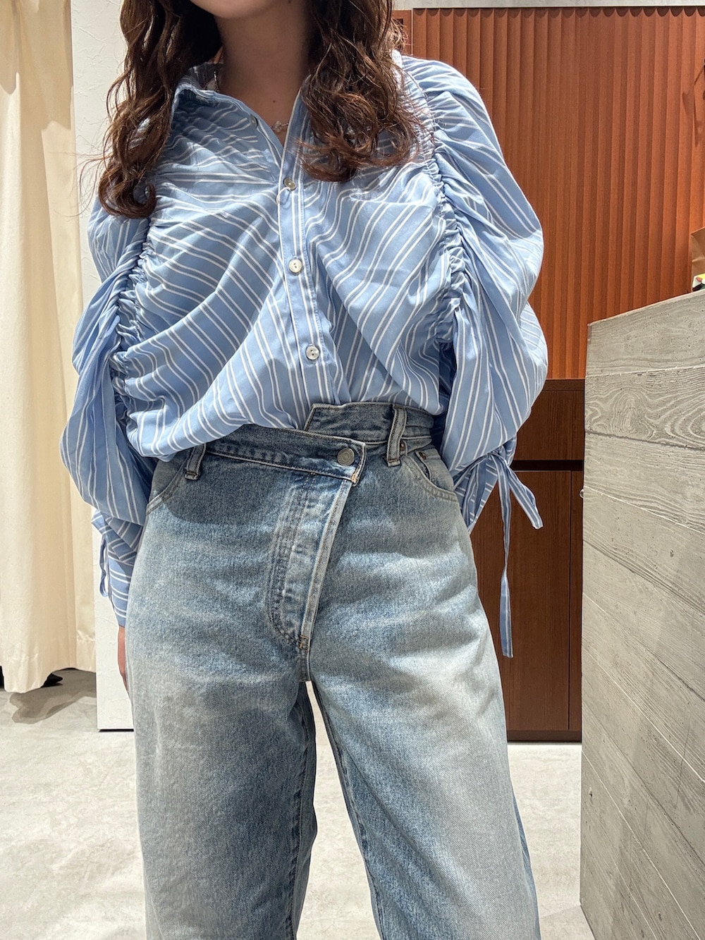 ブルー系のシャツ/ブラウス、ブルー系のデニムパンツ、ベージュ系のブーツを着用したレディースの春コーディネートの9枚目の写真