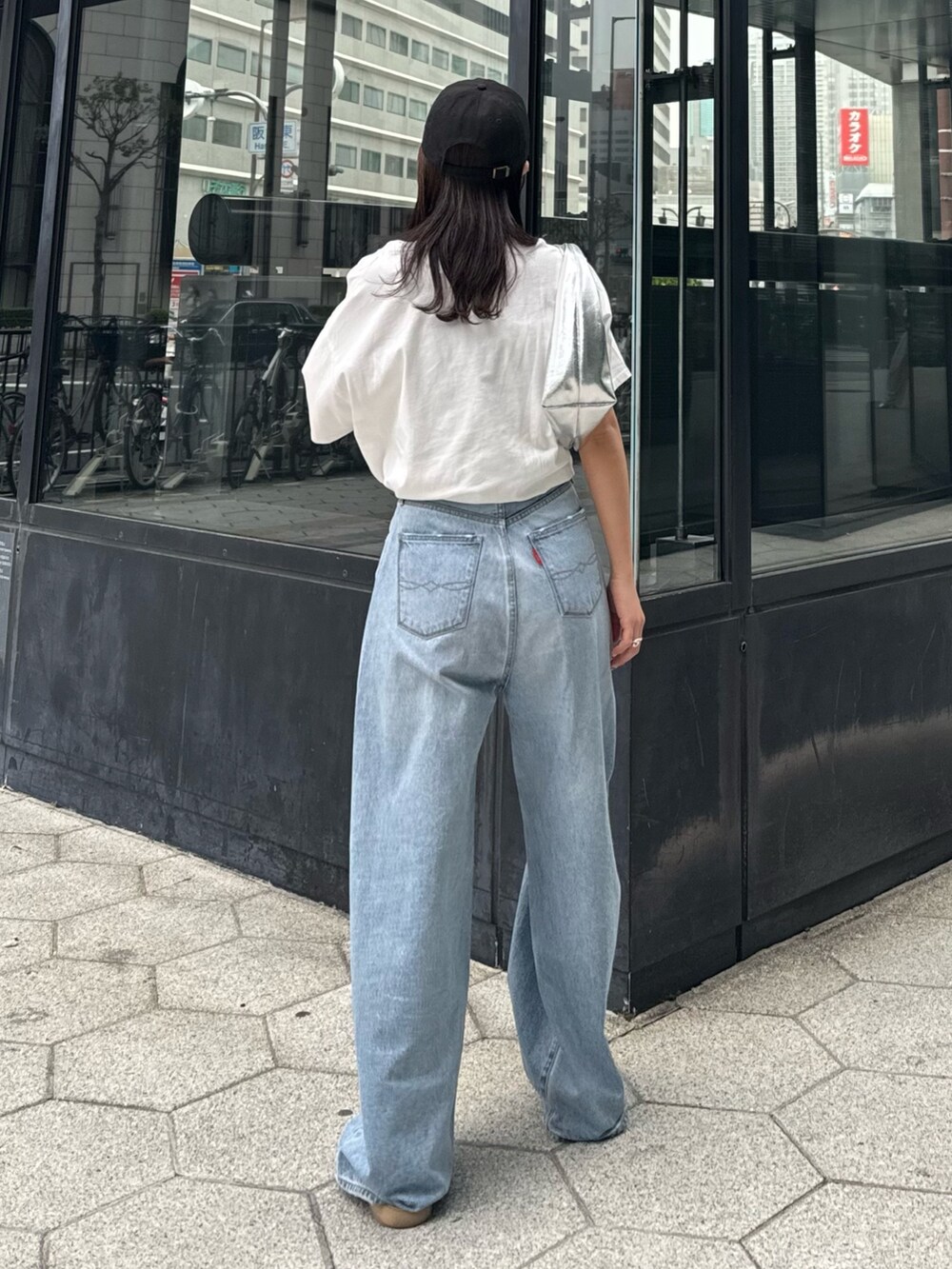 ブルー系のデニムパンツ、ホワイト系のTシャツ/カットソー、シルバー系のハンドバッグを着用したレディースの春コーディネートの6枚目の写真