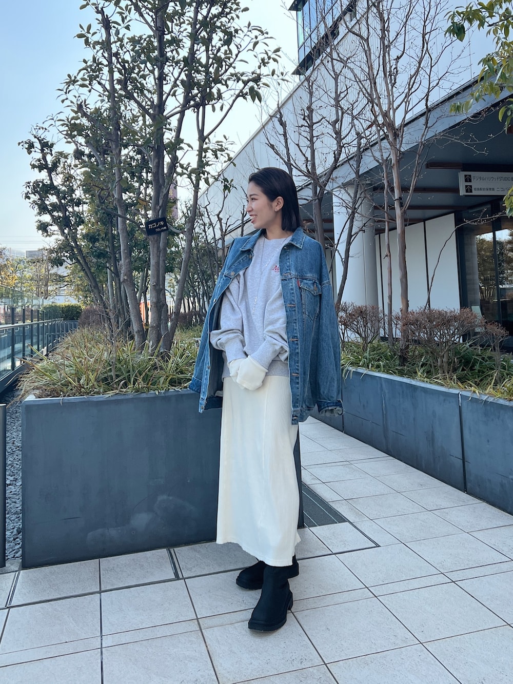 ブルー系のデニムジャケット、グレー系のスウェット、ホワイト系のワンピースを着用したレディースの冬コーディネートの4枚目の写真