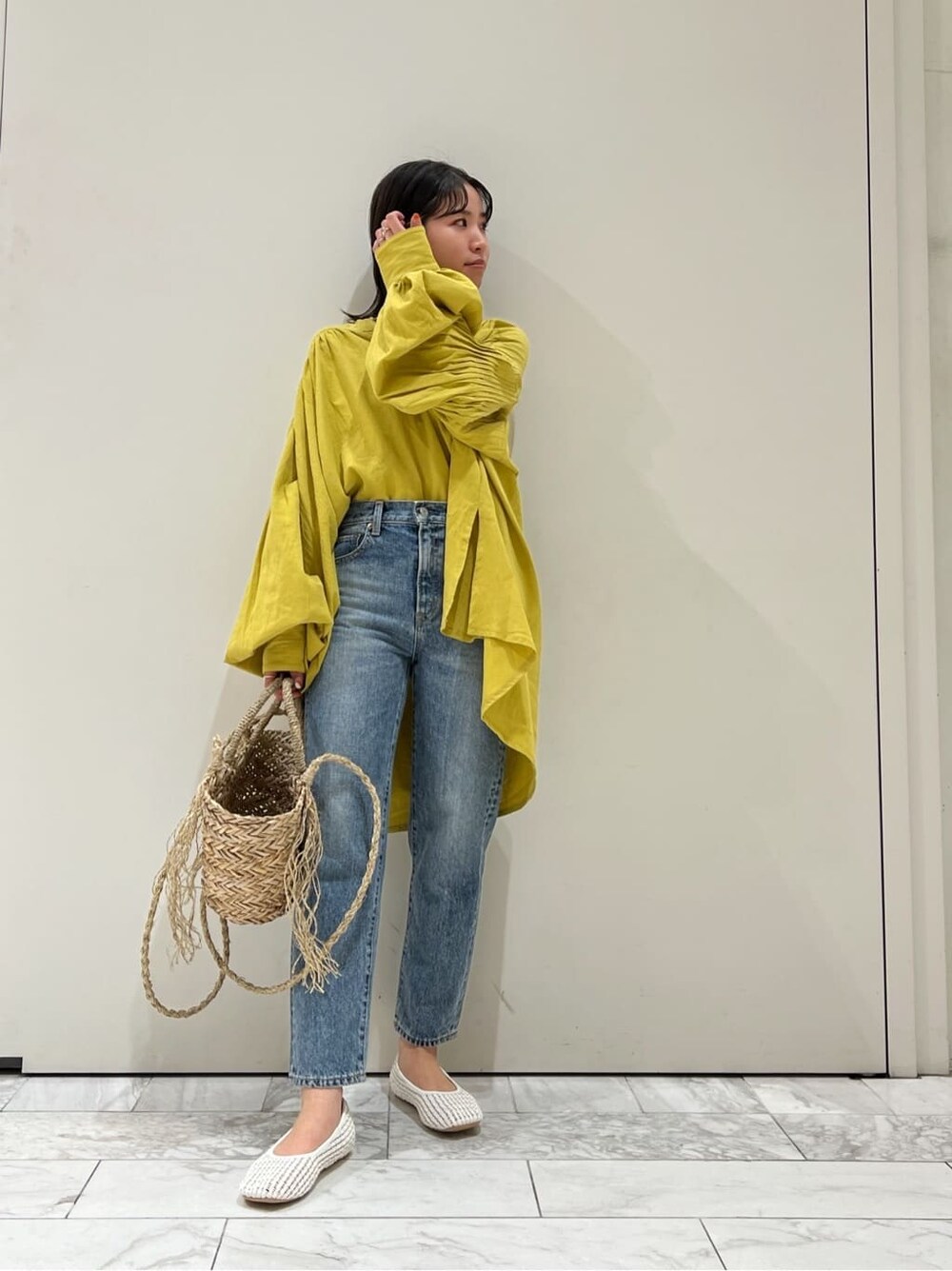 ホワイト系のパンプス、イエロー系のシャツ/ブラウス、ベージュ系のかごバッグを着用したレディースの春コーディネートの3枚目の写真