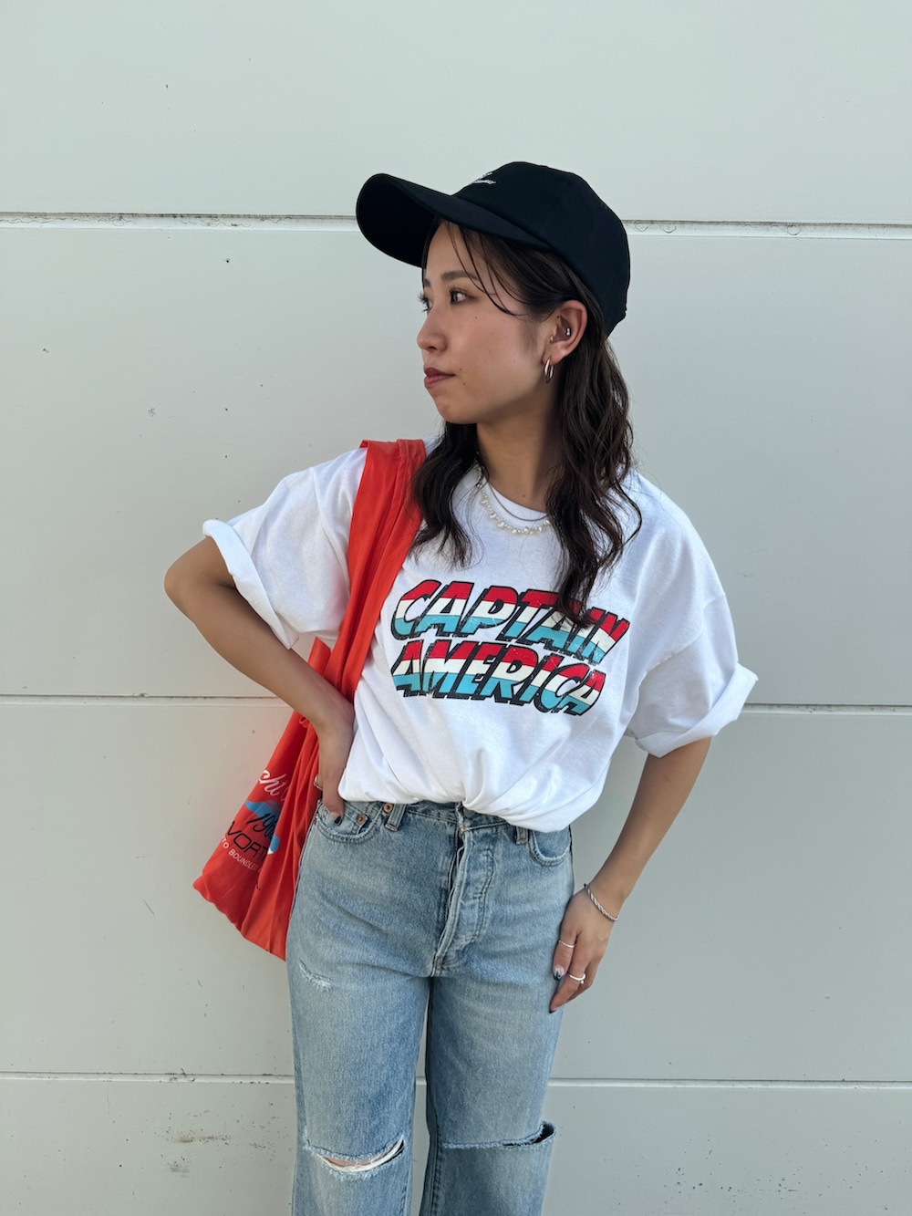 ブルー系のデニムパンツ、ホワイト系のTシャツ/カットソー、オレンジ系のエコバッグ/サブバッグを着用したレディースの夏コーディネートの10枚目の写真